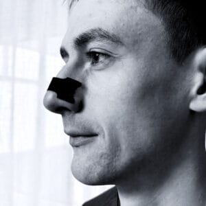 Mann som bruker Nesetape Pro Large – neseplaster for bedre pust, redusert snorking og bedre søvn.