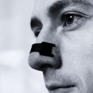 Mann som bruker Nesetape Pro Medium – neseplaster for bedre pust, redusert snorking og bedre søvn.