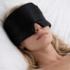 Kvinne som sover med svart Sovemaske Pro i silke på hvit pute for maksimal mørklegging og komfort
