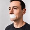 Mann med hvit munnteip fra Sovetape Pro for bedre nesepust og mindre snorking om natten